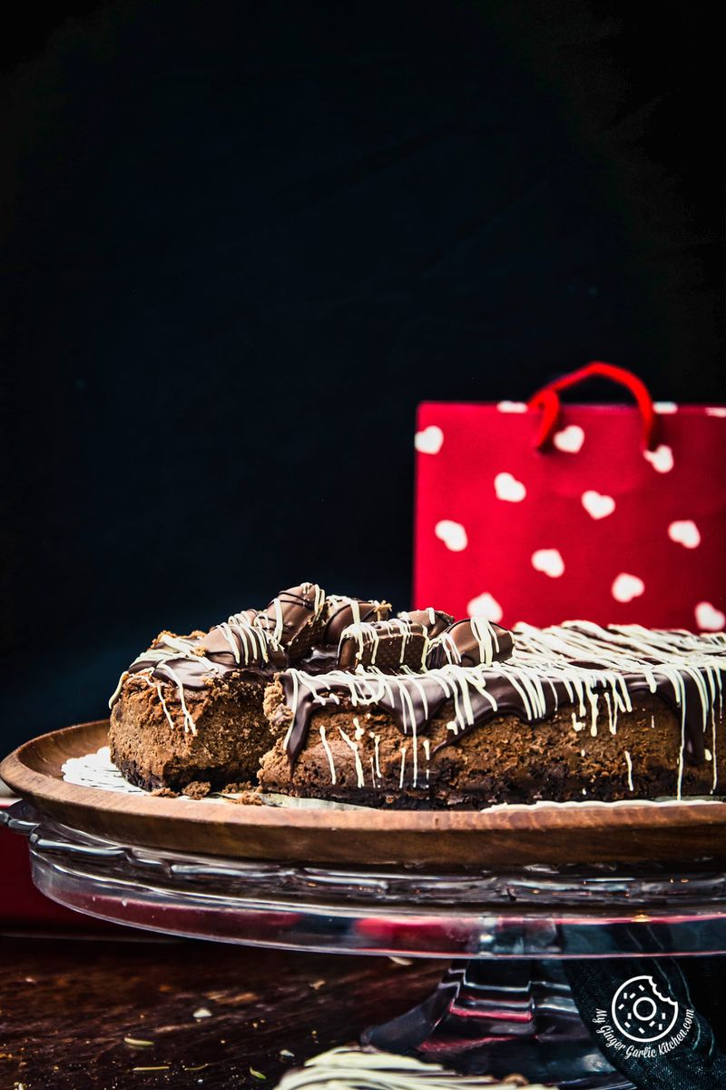 a chocolate cheesecake on a plate with a red gift bag