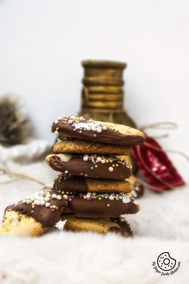 a stack of chocolate dipped whipped shortbread cranberry cookies sitting on a white table