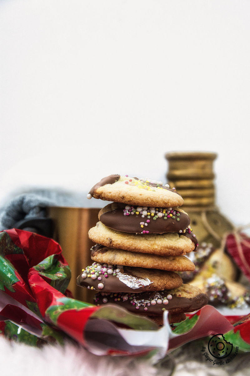 a stack of chocolate dipped whipped shortbread cranberry cookies sitting on a table