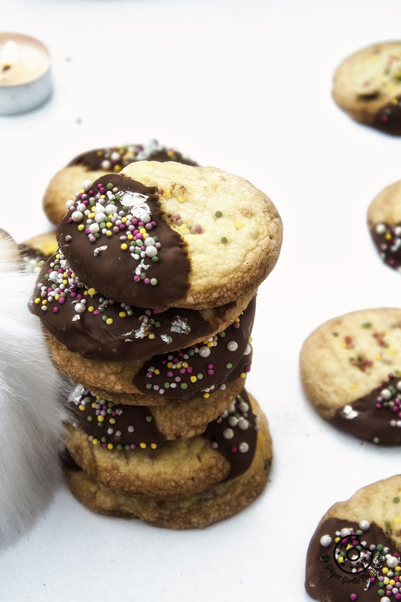 a stack of chocolate dipped whipped shortbread cranberry cookies sitting on a table