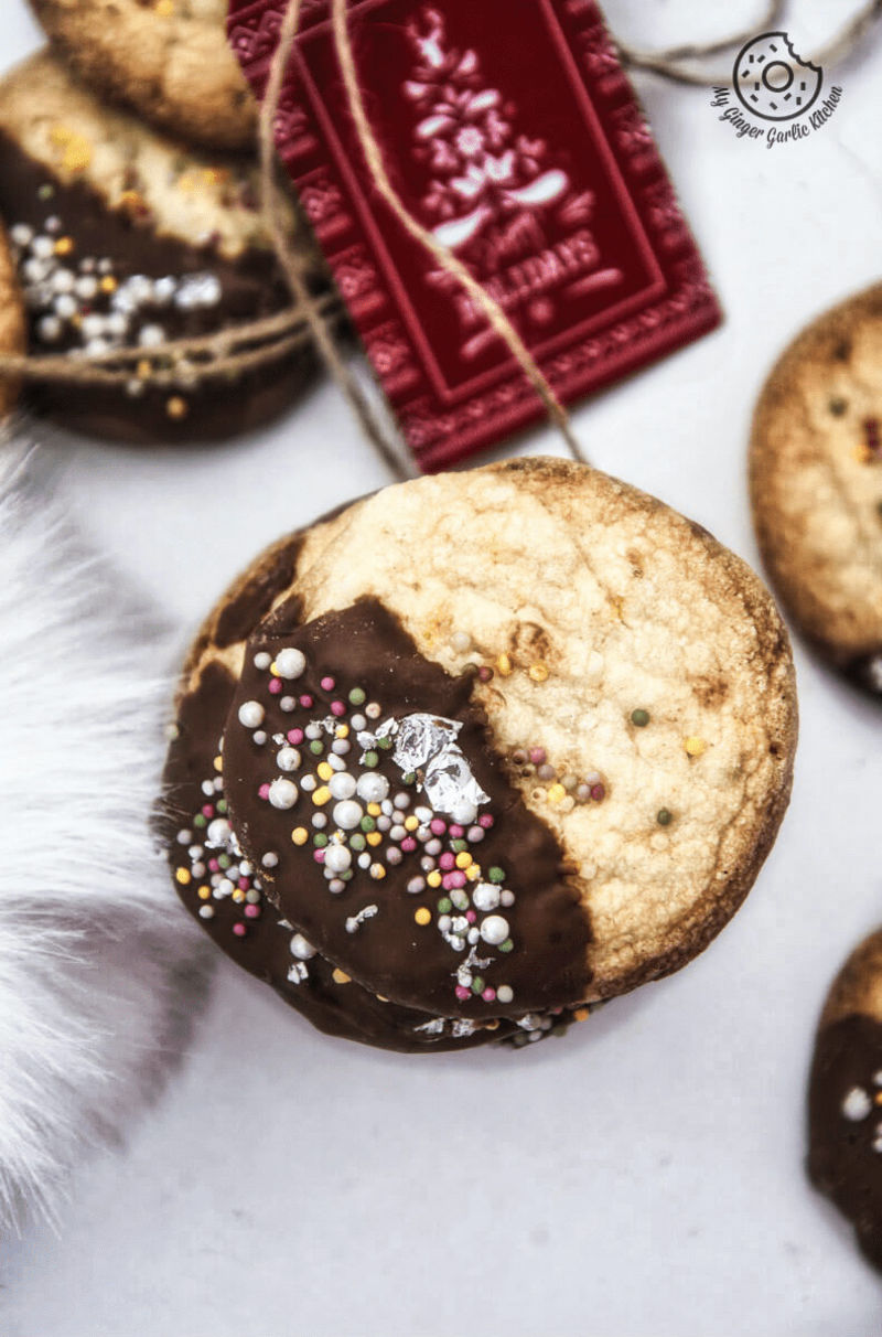 a stack of chocolate dipped whipped shortbread cranberry cookies sitting on a table