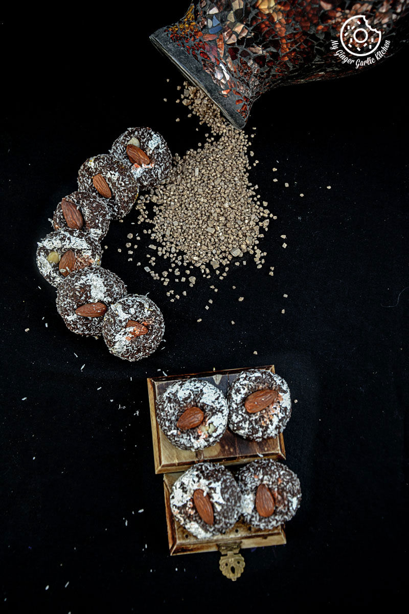 chocolate coconut delights topped with almonds on a black surface