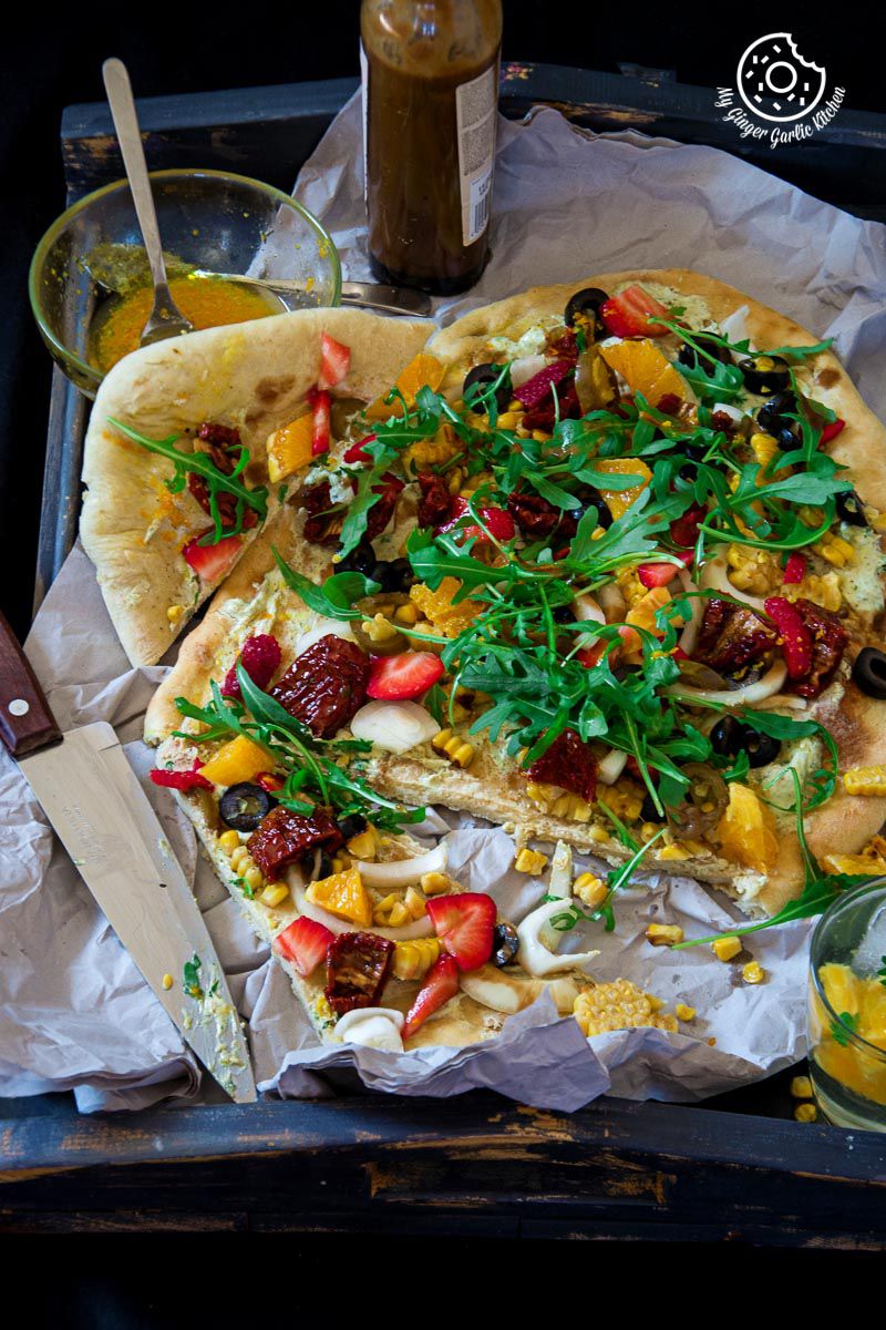 corn cream cheese flatbread orange vinaigrette with vegetables and fruit on a tray