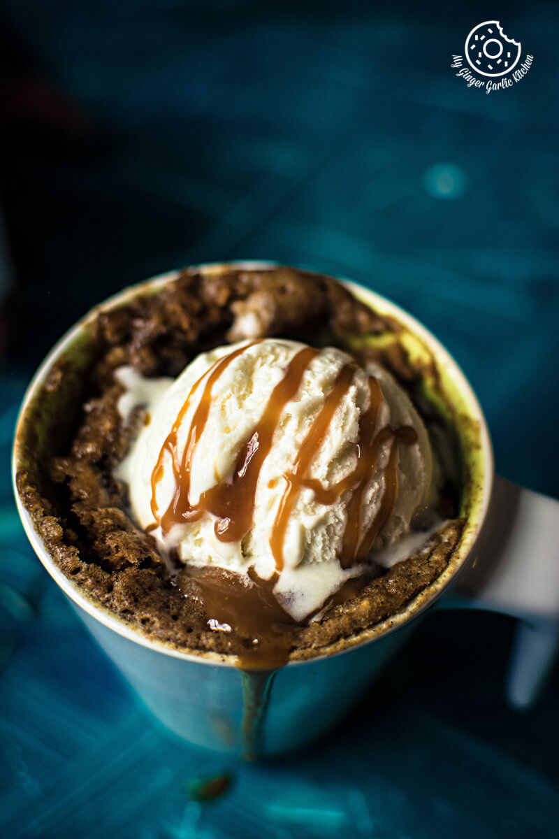 two cups of eggless apple pie mug cake with ice cream and caramel
