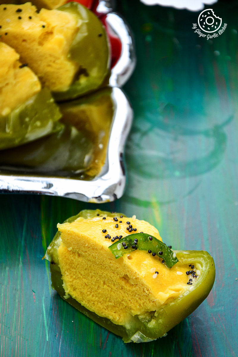 there is a green bell pepper with filled gujarati khaman dhokla
