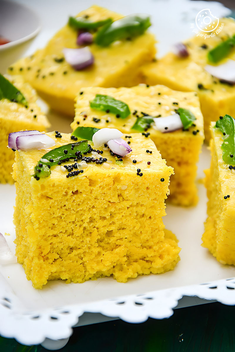 a lot of gujarati khaman dhoklas on a plate on a table