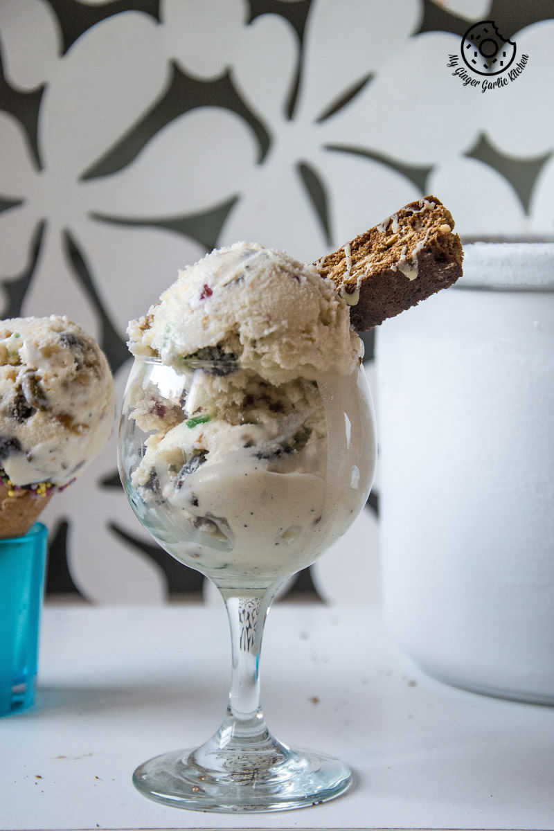 a glass of holiday fruit and nut ice cream with a cookie on top