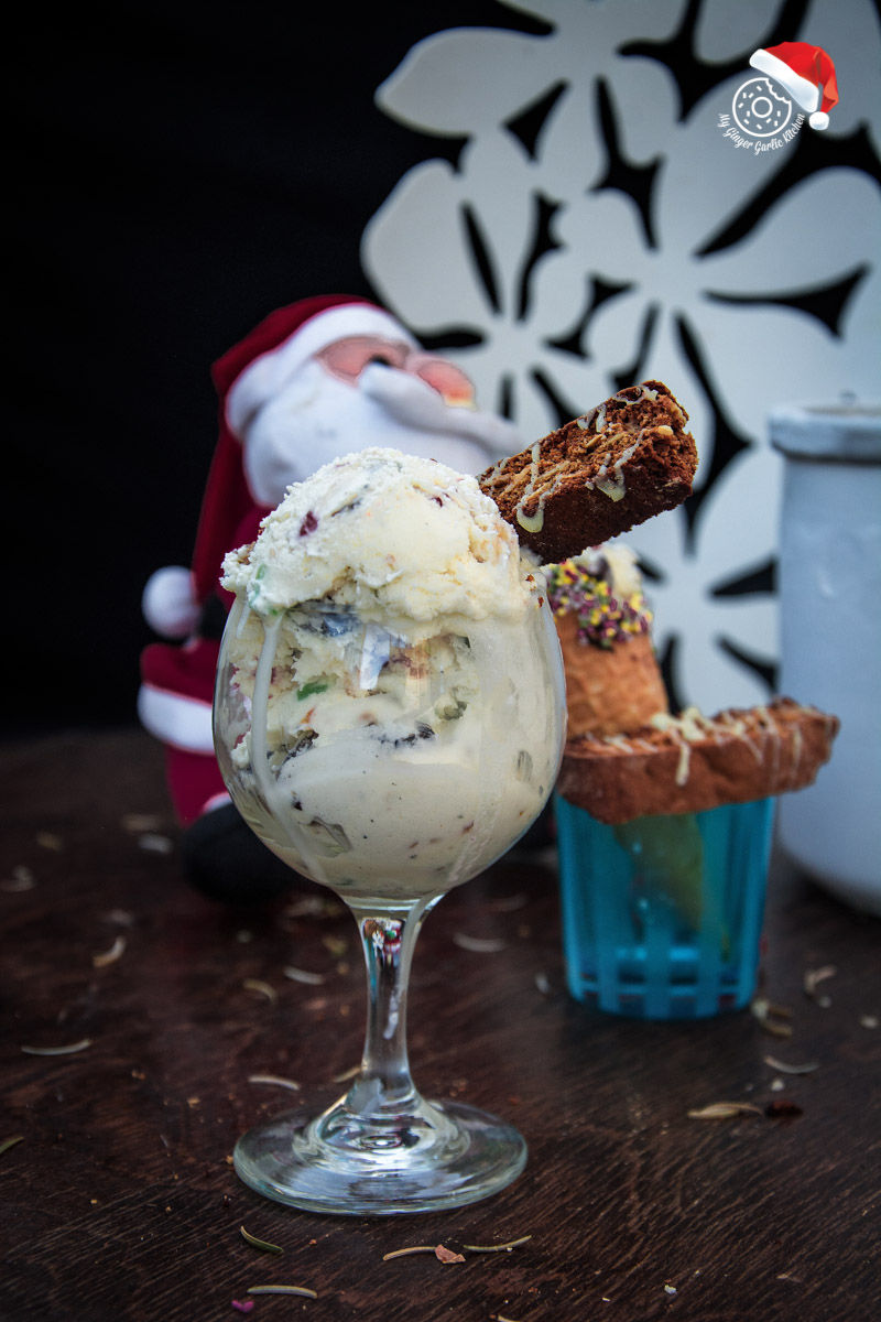 a glass of holiday fruit and nut ice cream with a biscotti in it