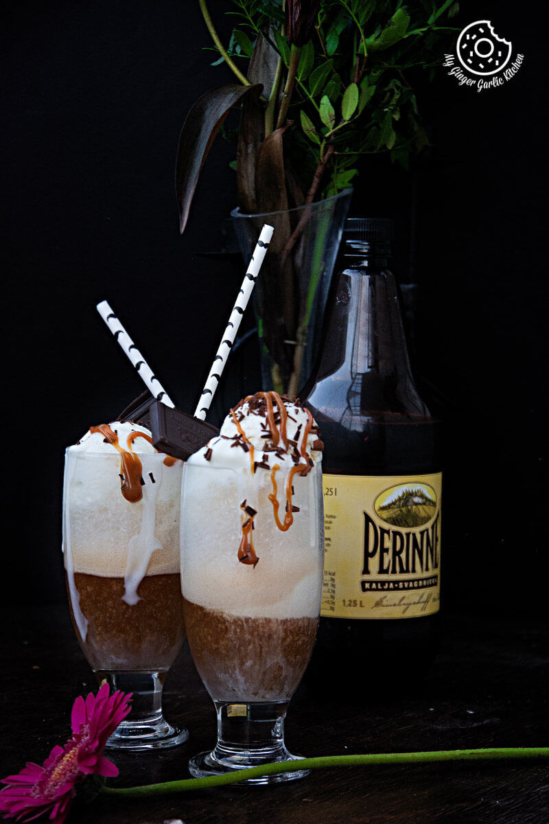 two glasses of home brewed beer float with ice cream, chocolate sprinkles, and caramel on top