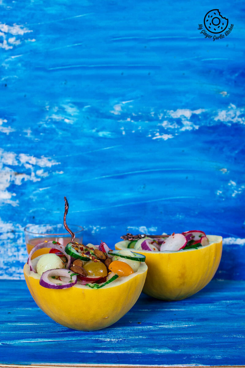 two bowls of honeydew melon radish salad bowls on a blue table