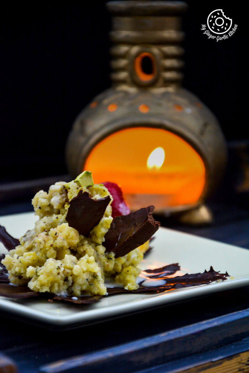 a plate of jaipuri mishri mawa with a chocolate decoration and a candle