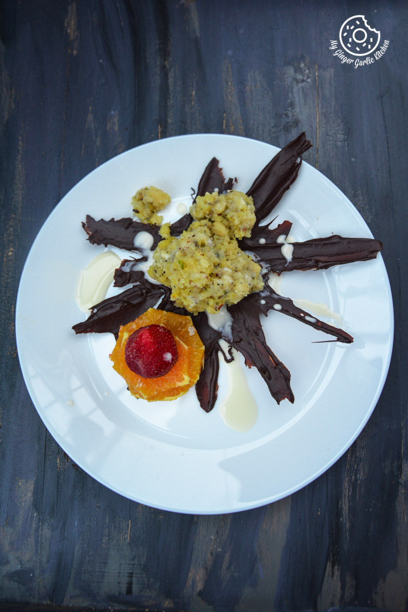 a plate of jaipuri mishri mawa with chocolate and fruit on it