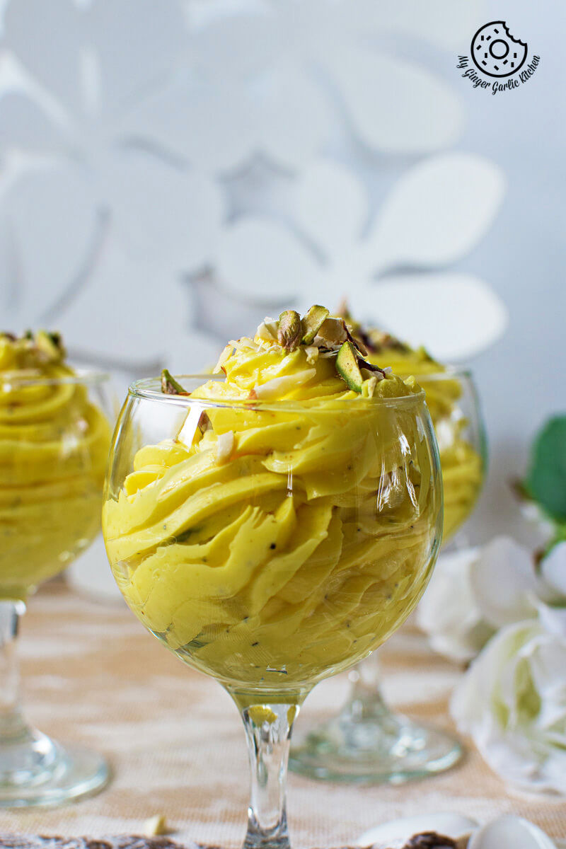 two glasses of kesar elaichi shrikhand topped with pistachios