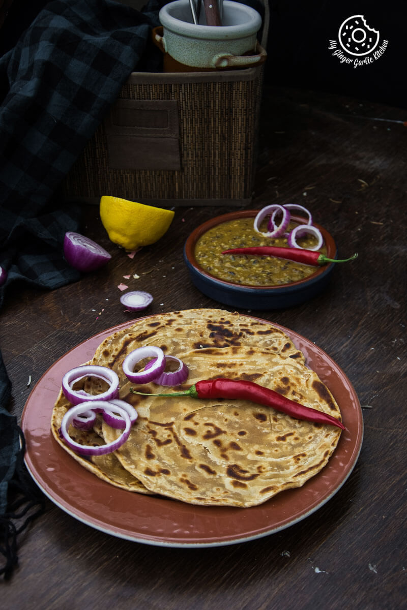 there is a plate of lachha paratha that has some onions on it