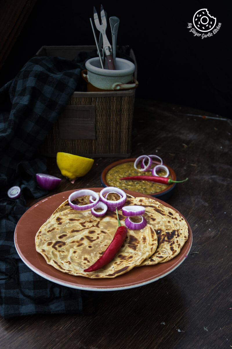 there is a plate of lachha paratha that has onions and peppers on it