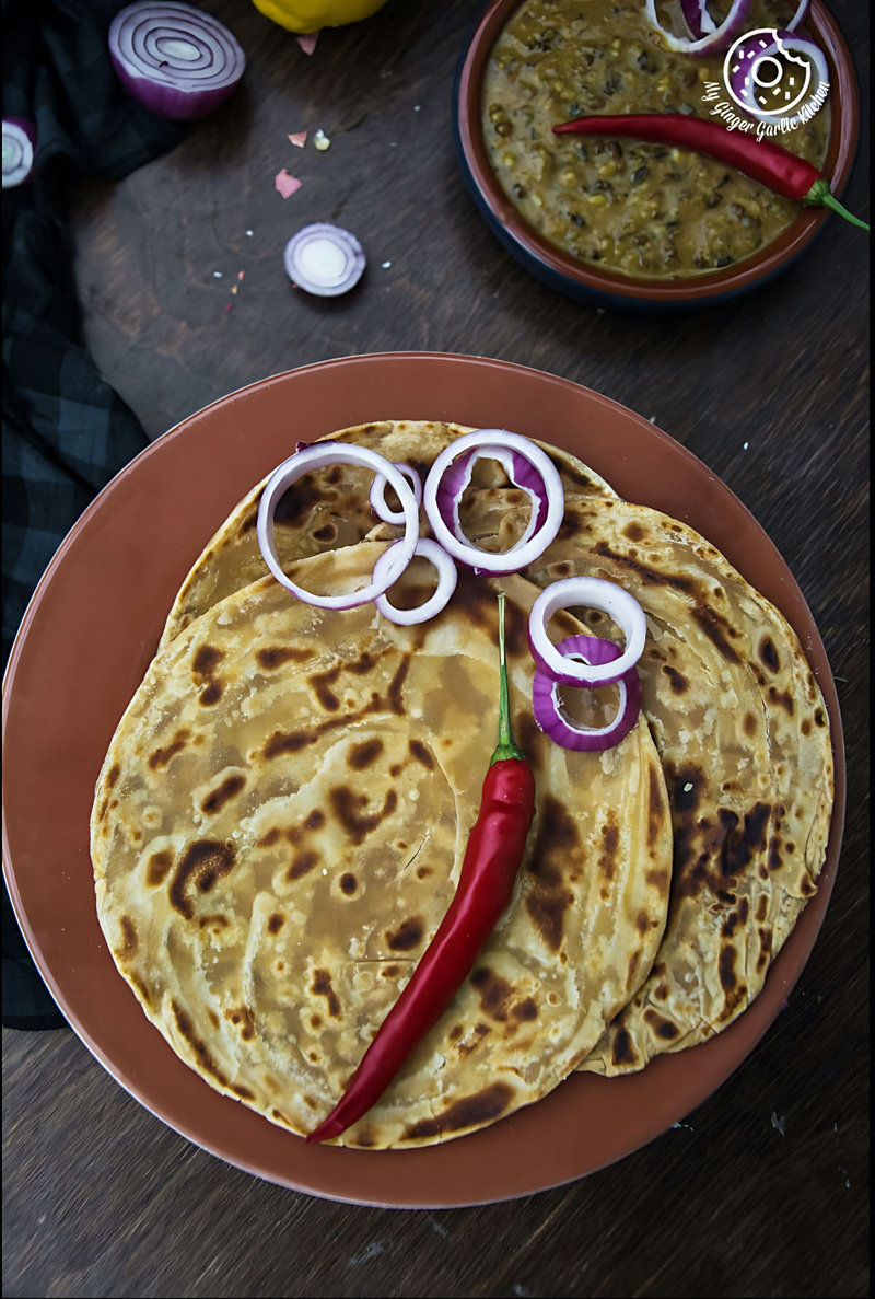 there is a plate of three lachha parathas with a face made of tortillas