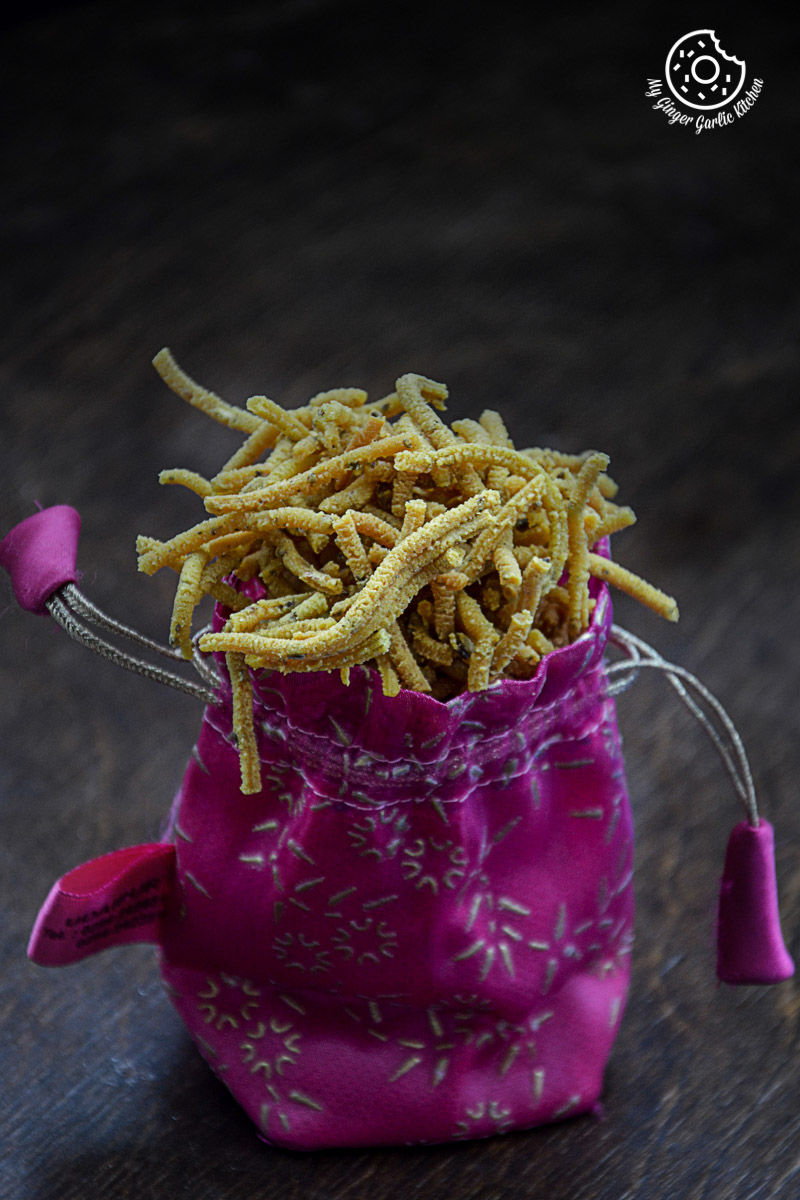 a pink bag filled with lehsuni sev or garlicky chickpea noodles on a table