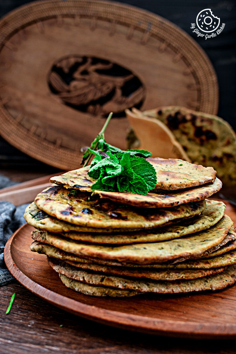 a lot of mint coriander tandoori roti on a wooden plate on a table