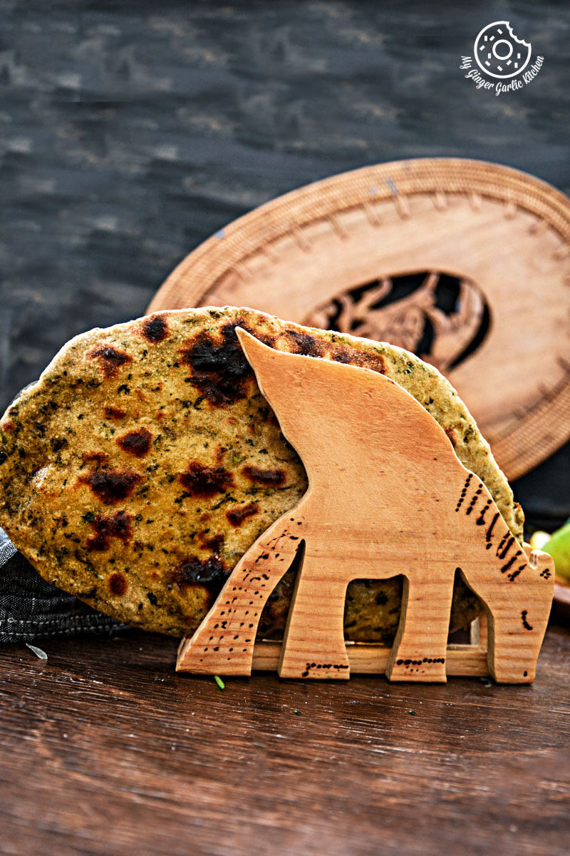 a wooden plate with a mint coriander tandoori roti on it