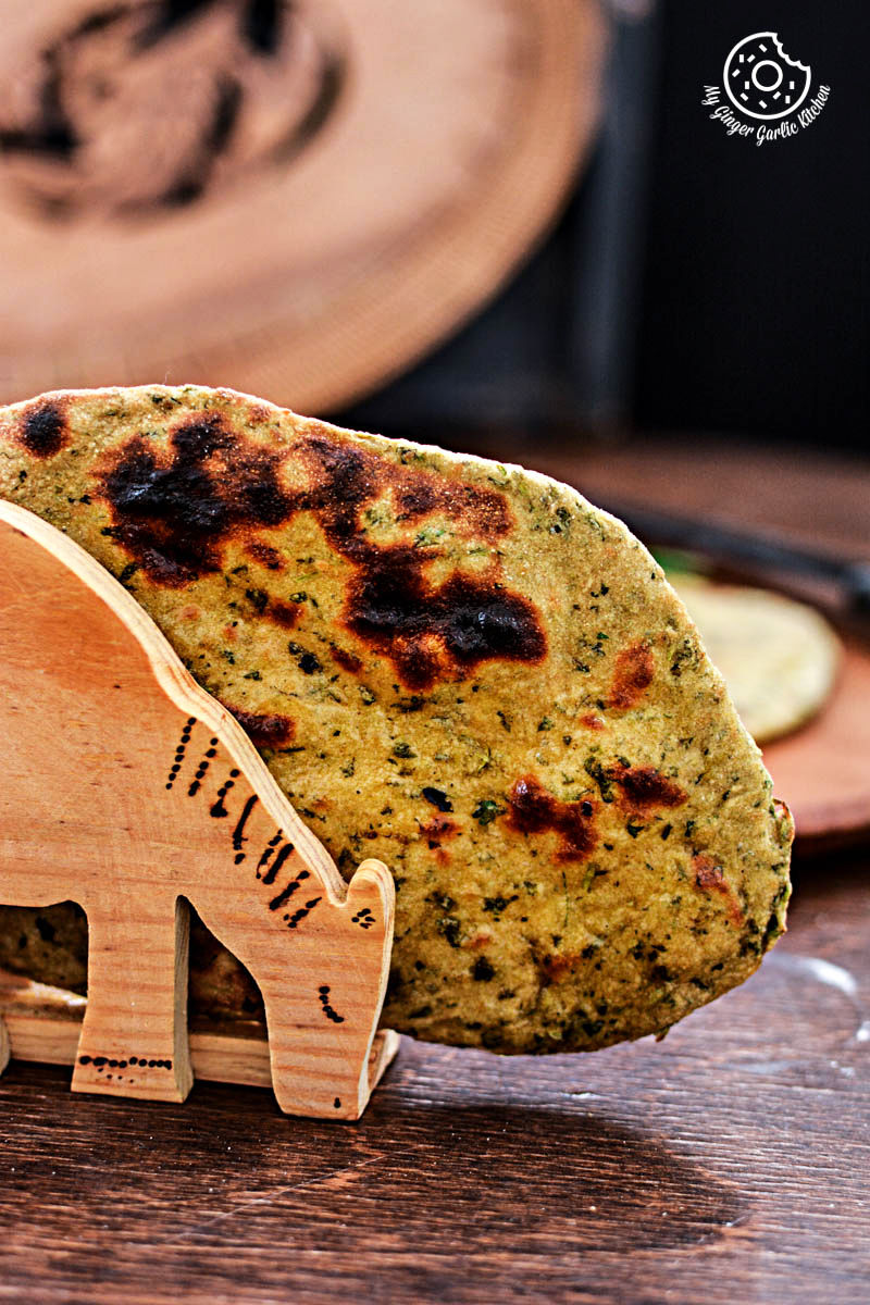 a wooden animal shaped holder with mint coriander tandoori roti on a table