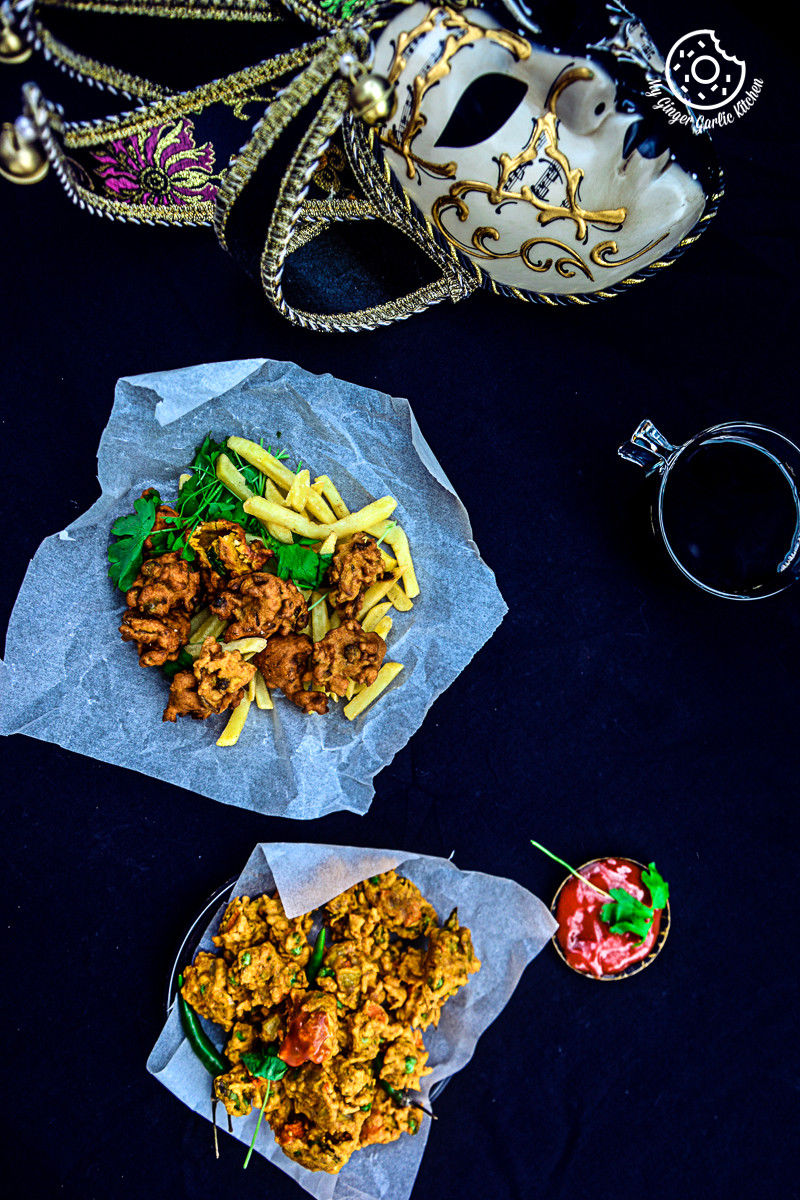 two plates of mix veg pakoras on a table with a mask