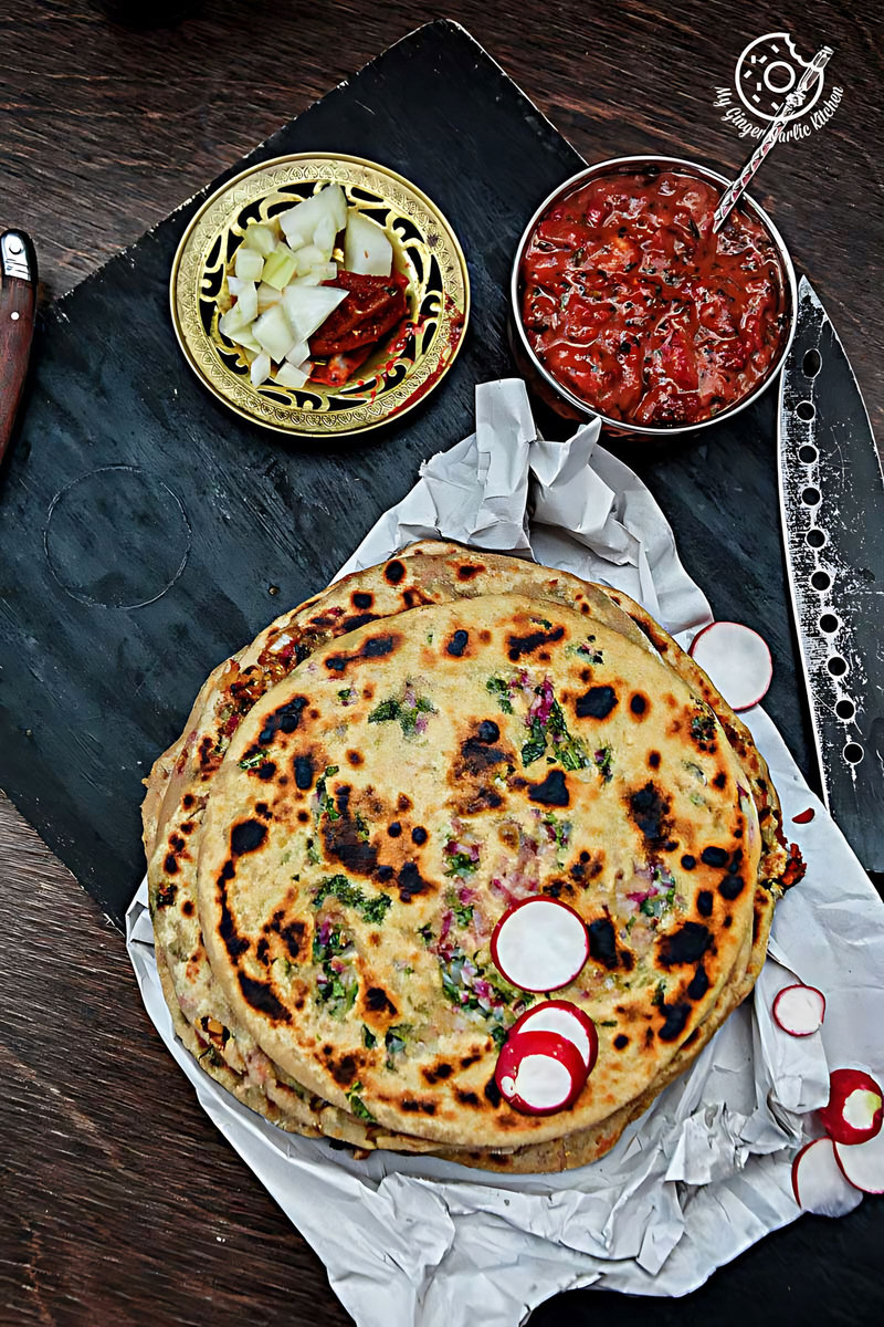 mooli paratha with strawberry grape chutney on a table with a knife