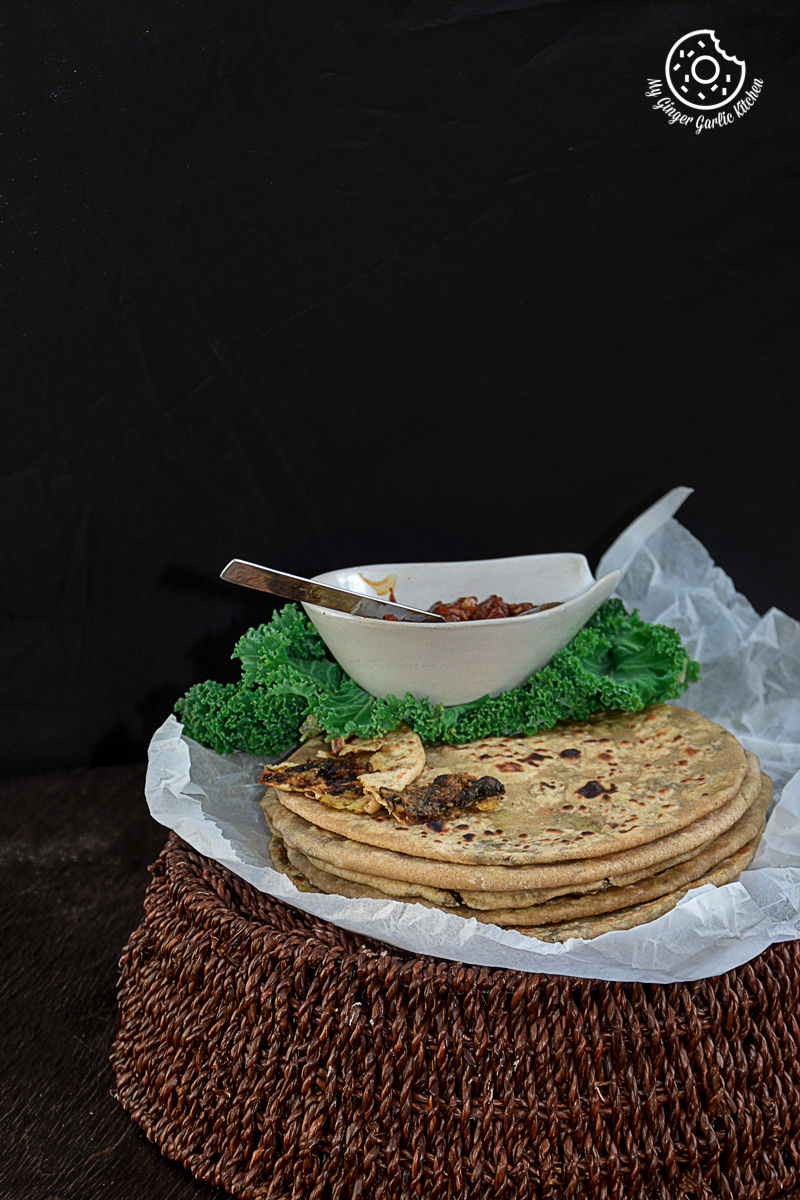 a plate of mushroom kale stuffed paratha that is on a table