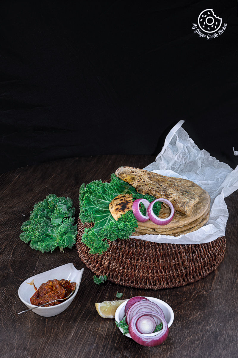 a basket with some mushroom kale stuffed parathas on it on a table