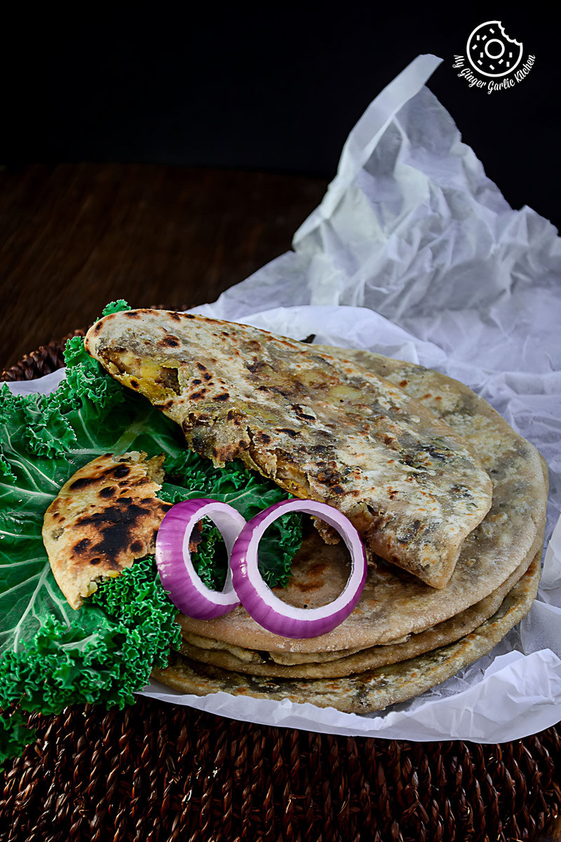 a plate of mushroom kale stuffed parathas with kale and onions