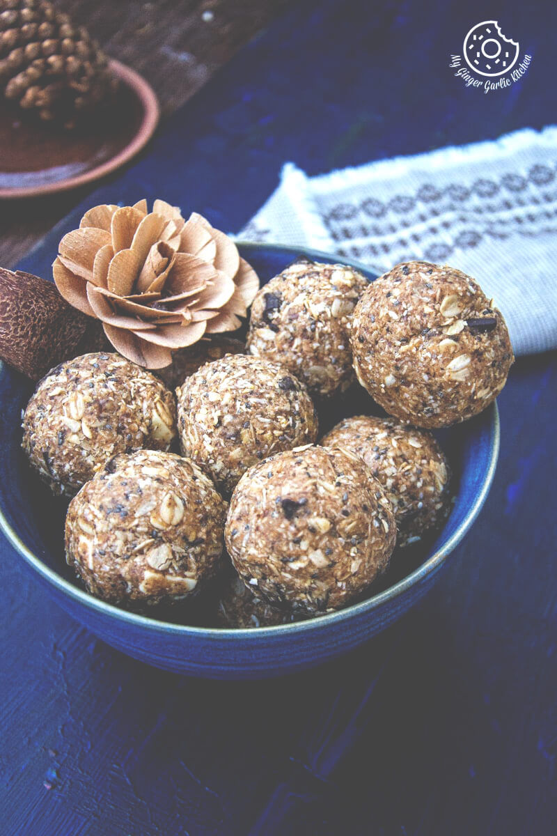 a bowl of no bake oats and chia energy balls and a pine cone on a table