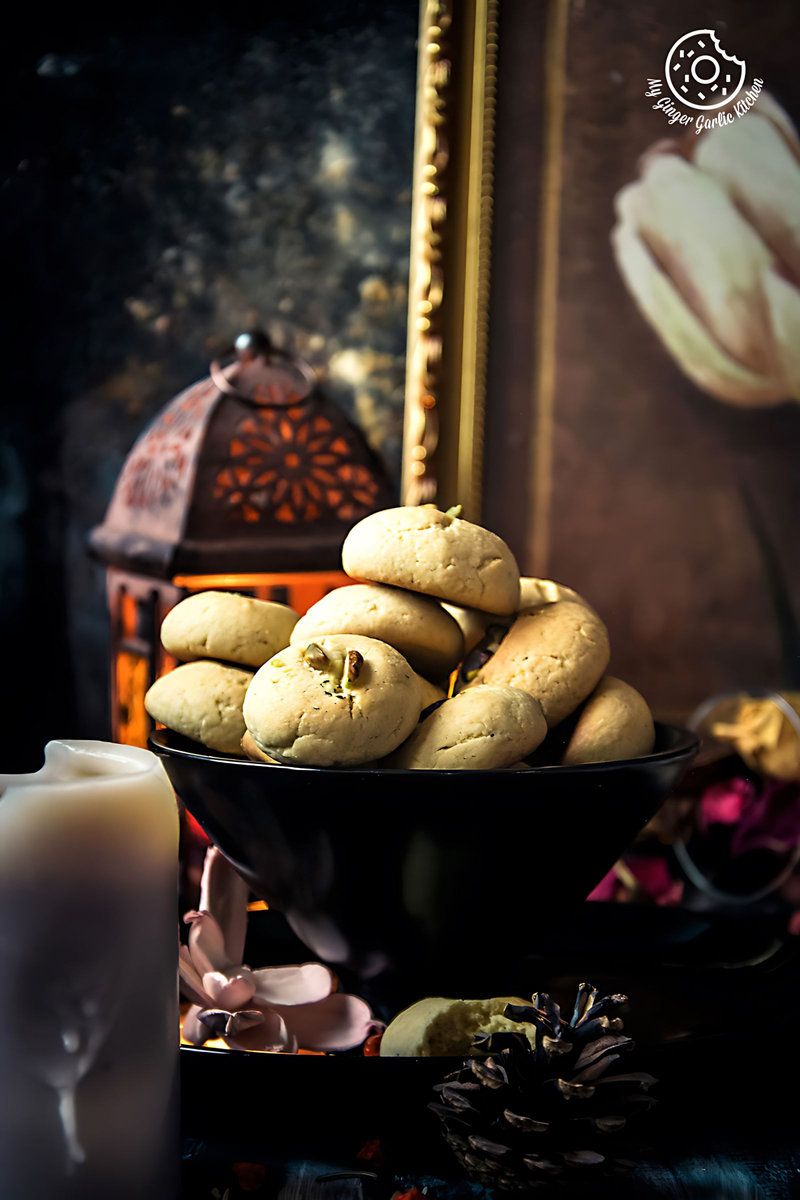 a bowl of Indian nankhatai cookies on a table with a candle