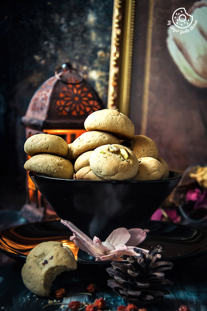 a bowl of nankhatai cookies on a table with a candle