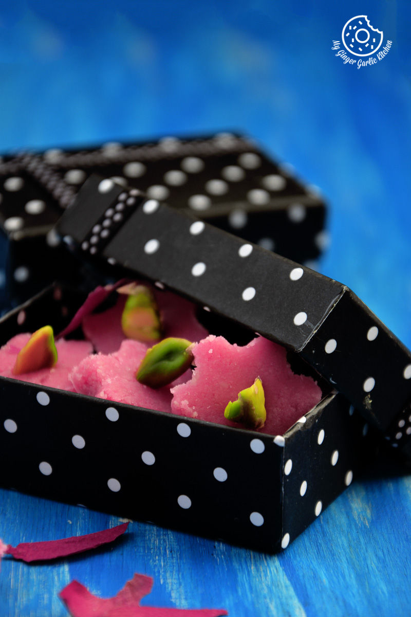 a small black box with a pink and green no bake almond flowers inside