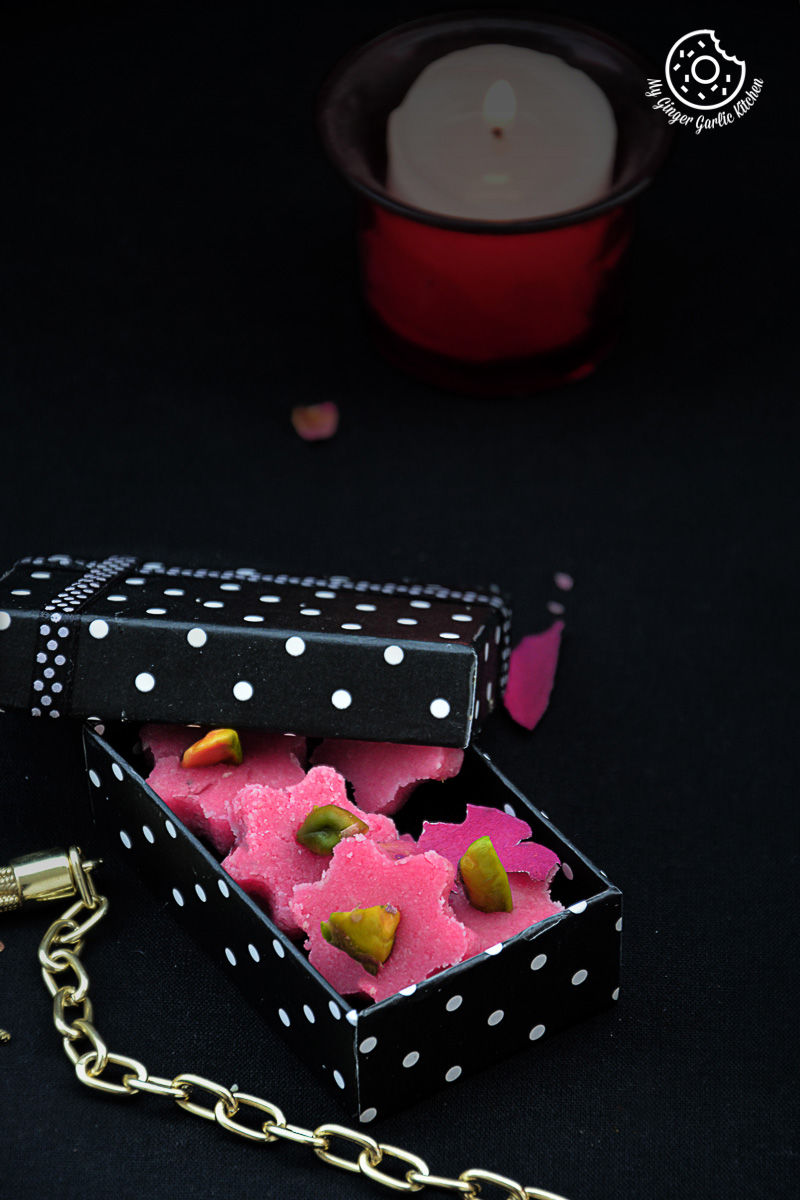 a small box with some pink no bake almond flowers inside of it