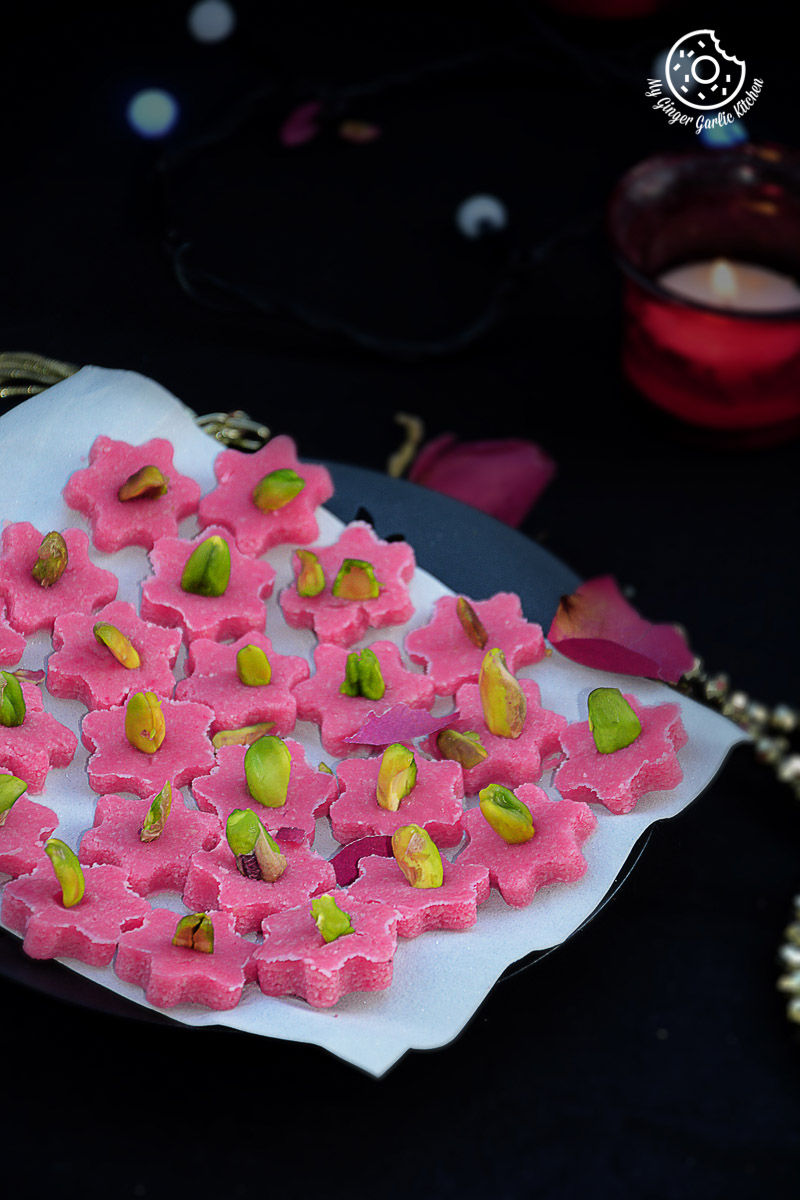 a plate of pink and green no bake almond flowers on a table