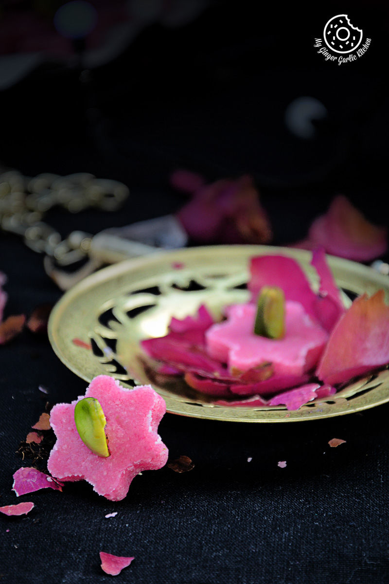 a plate with pink no bake almond flowers on it on the table