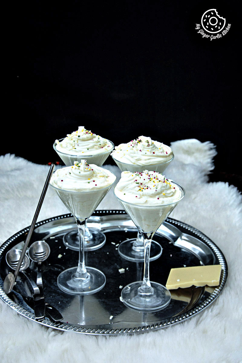 four glasses of no bake cream cheese lemon mousse on a tray with a spoon