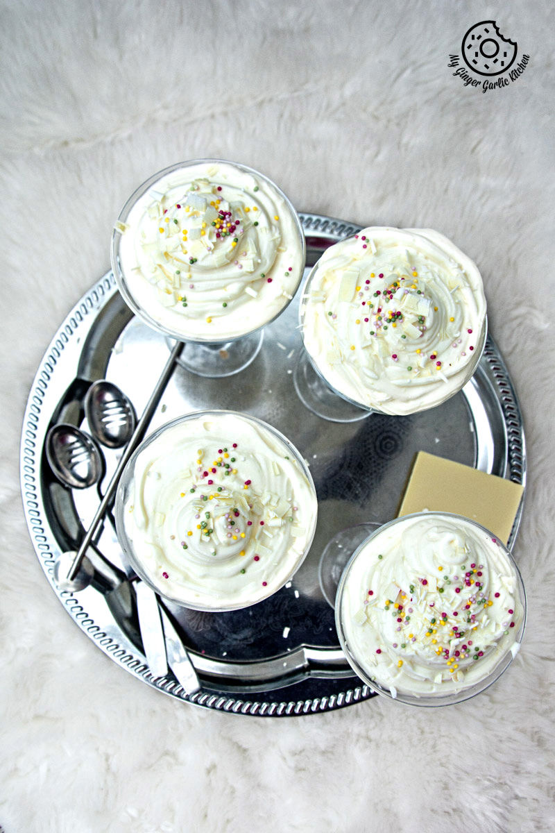 four no bake lemon cheesecake mousse on a silver tray with a spoon