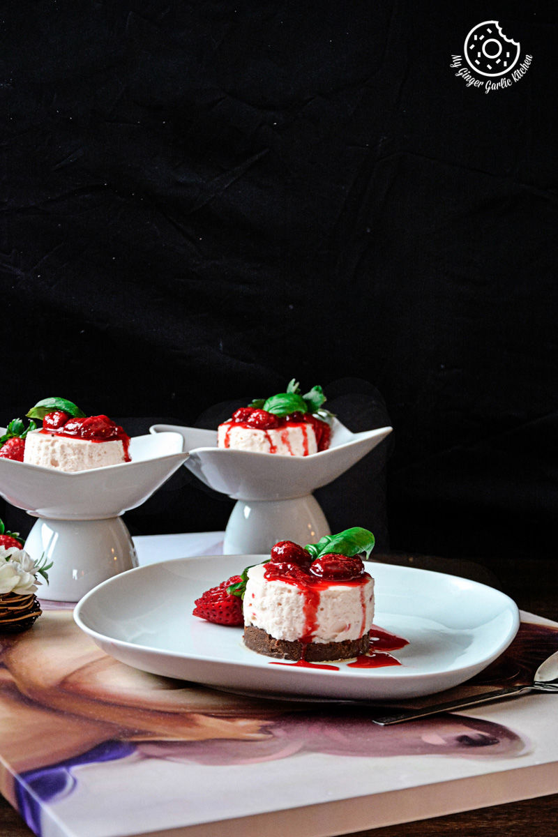 three white plates with no bake mini strawberry cheesecake and strawberry compote on them