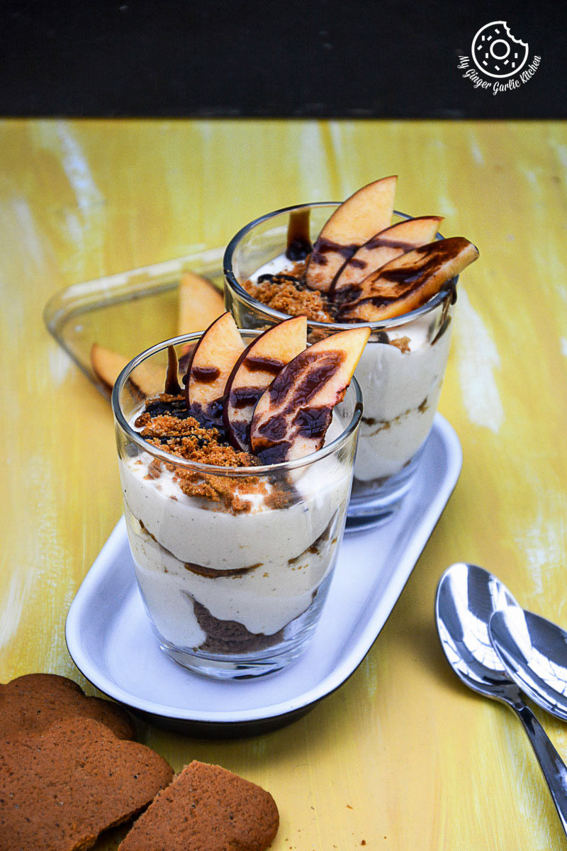 two no bake peach gingerbread cheesecake parfaits cups on a plate