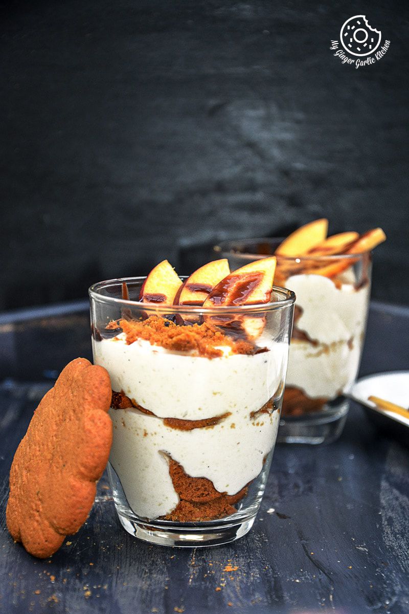 two no bake peach gingerbread cheesecake parfait in glasses with a gingerbread cookie on the side