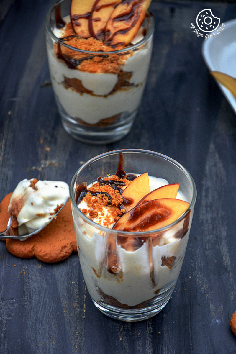 two no bake peach gingerbread cheesecake parfaits in small glasses on a table