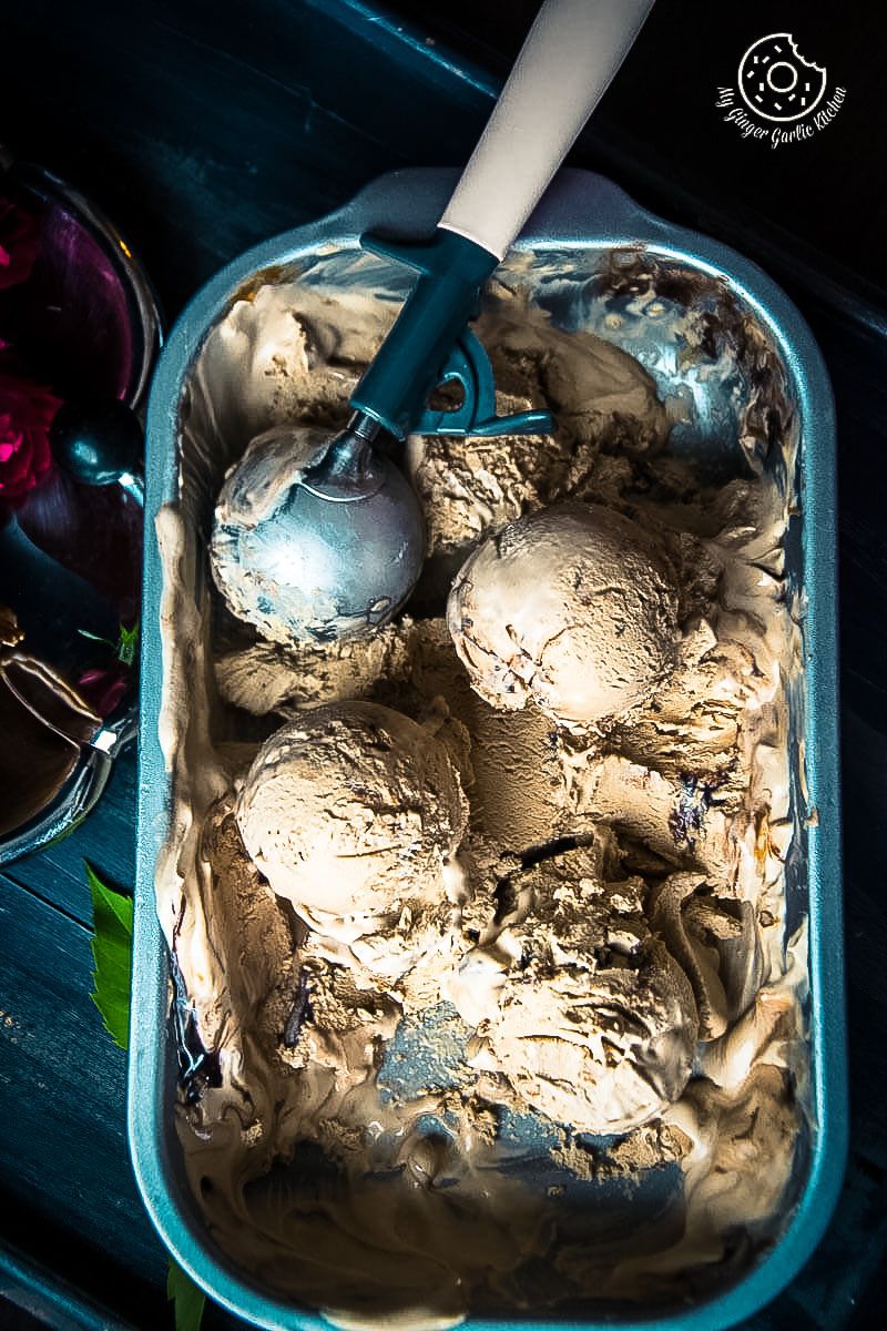 a container of no churn coffee caramel chocolate ice cream with a scoop of ice cream