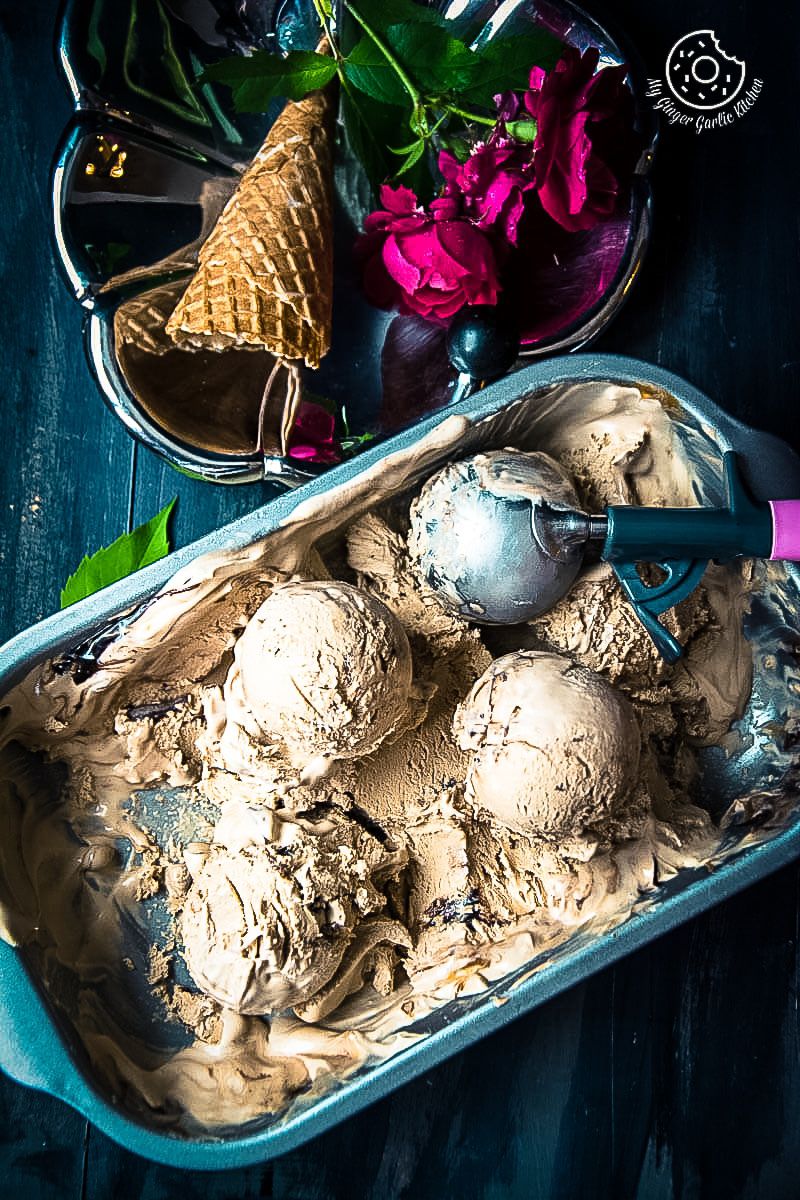 a tray of no churn coffee caramel chocolate ice cream with a scoop of ice cream