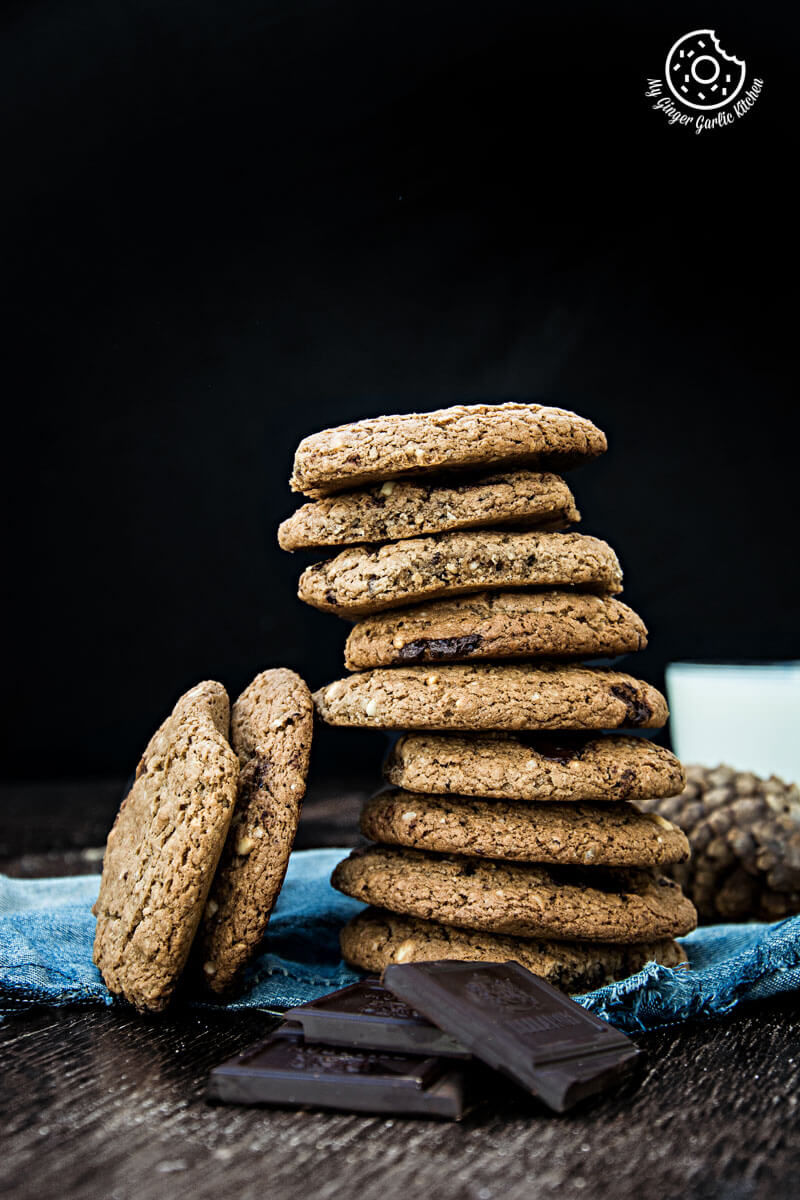a stack of oatmeal peanut butter chocolate cookies on a table with chocolate