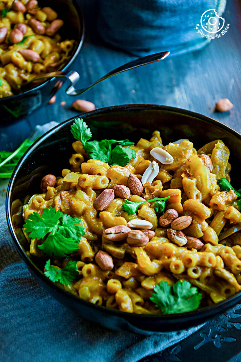 a bowl of one pan thai yellow curry macaroni with peanuts and parsley