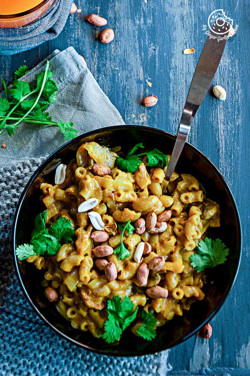 a bowl of one pan thai yellow curry macaroni with nuts and parsley