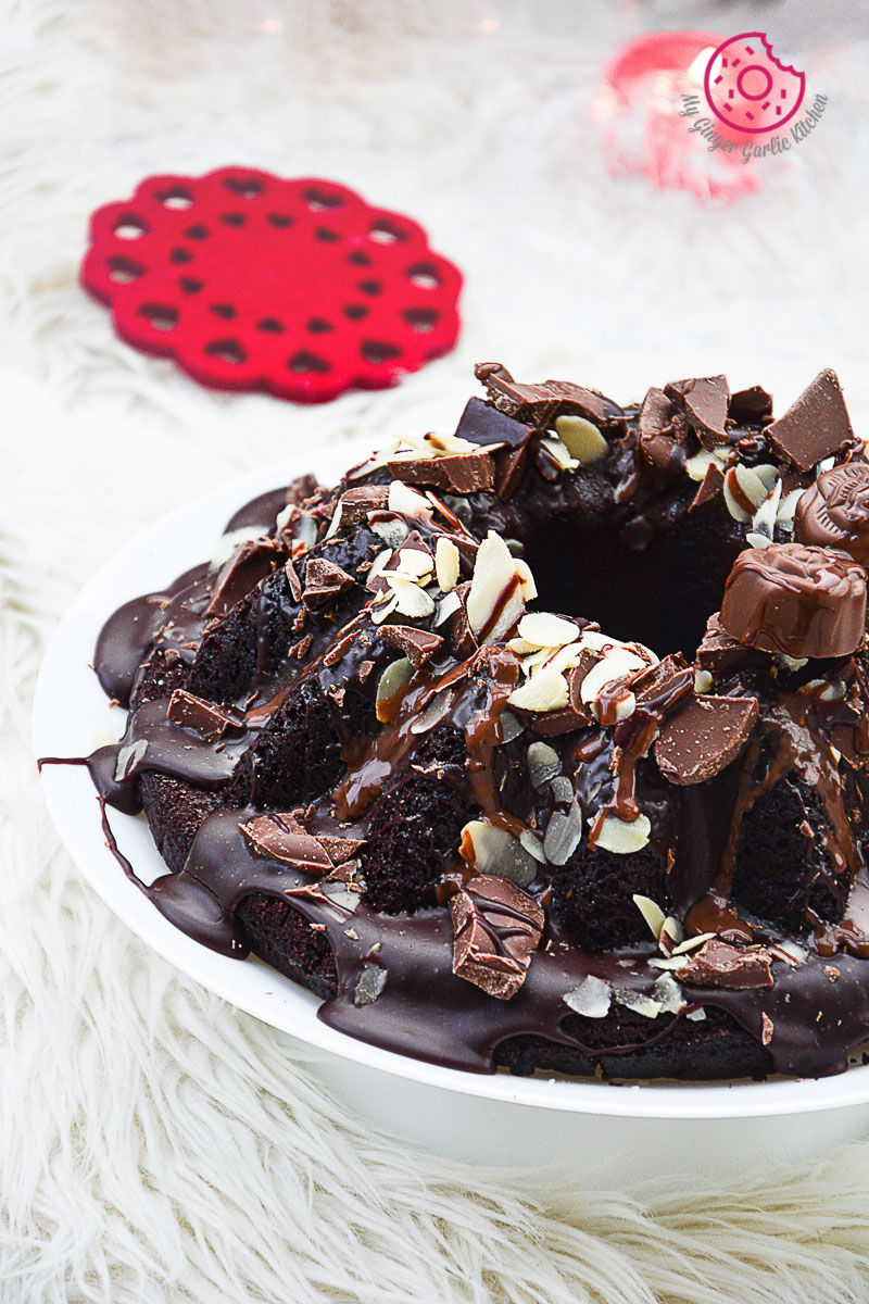 a plate of persimmon chocolate bundt cake with chocolate frosting and nuts on top