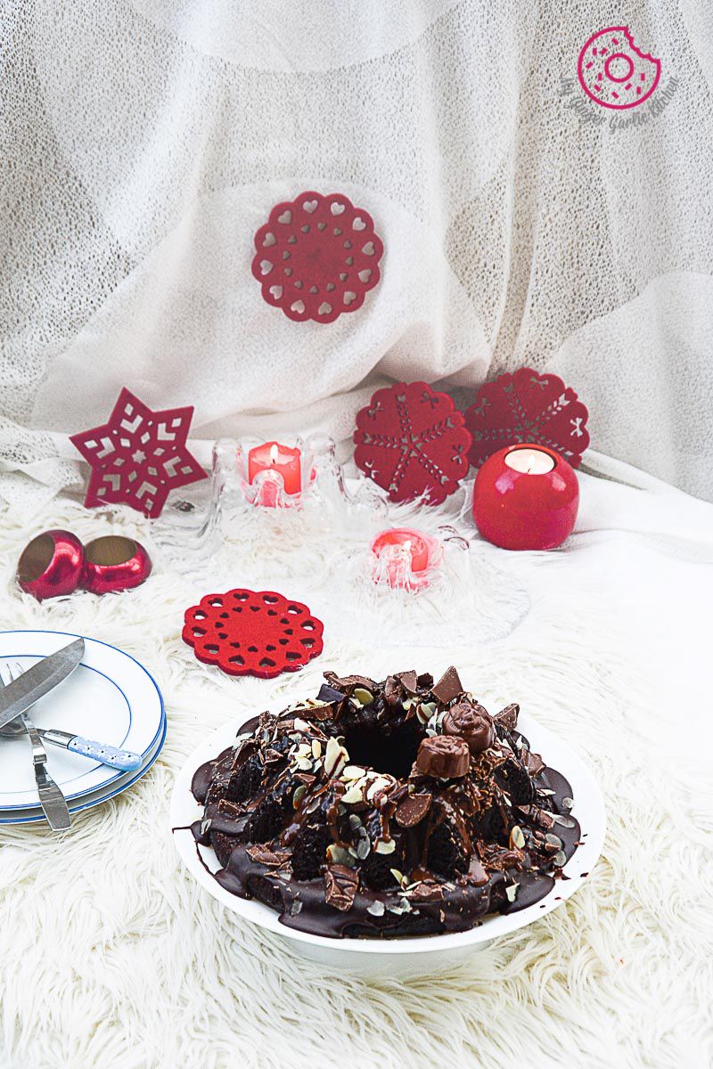 a plate of persimmon chocolate bundt cake on a white table setup with red decor