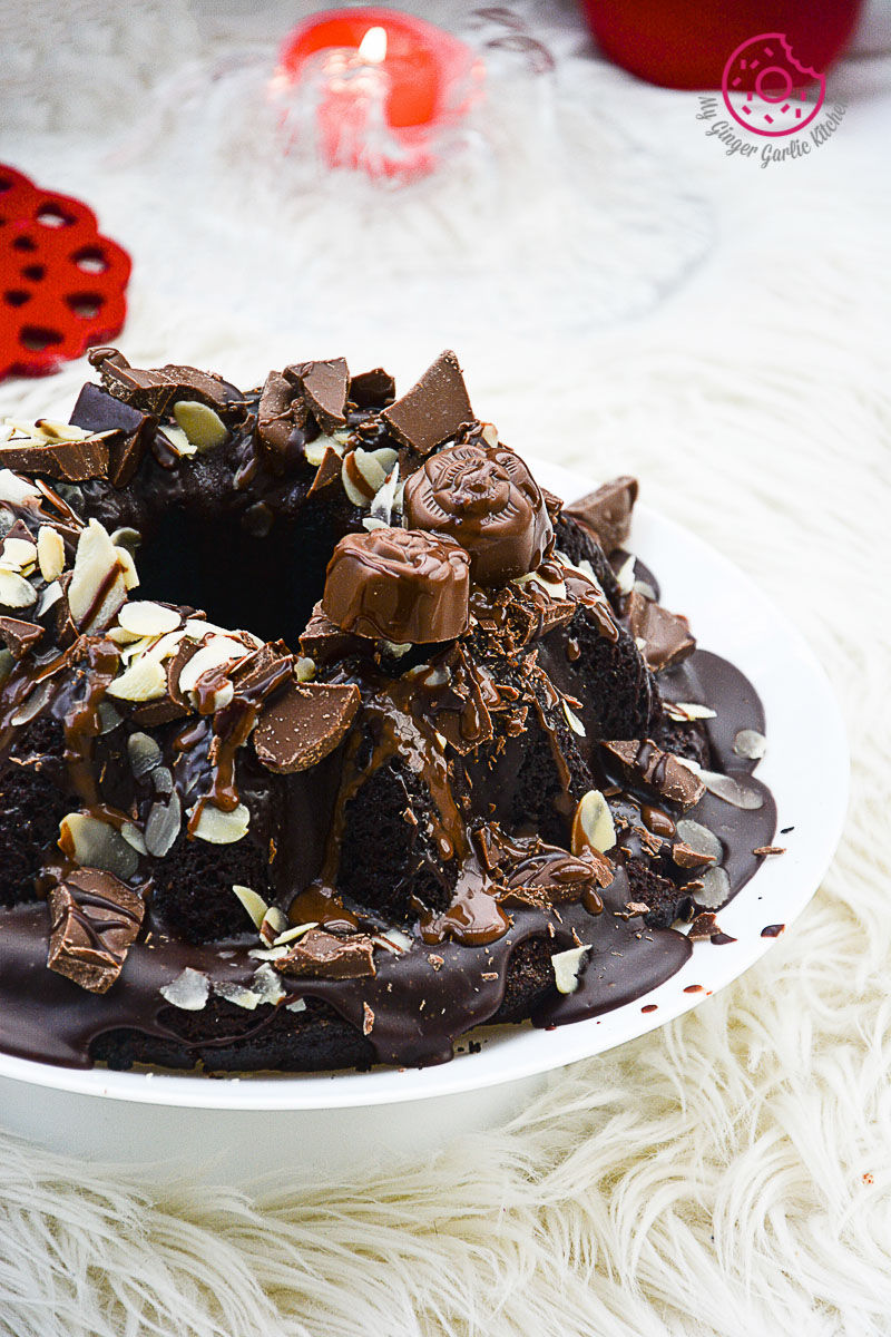 a plate of persimmon chocolate bundt cake with chocolate frosting and nuts on it